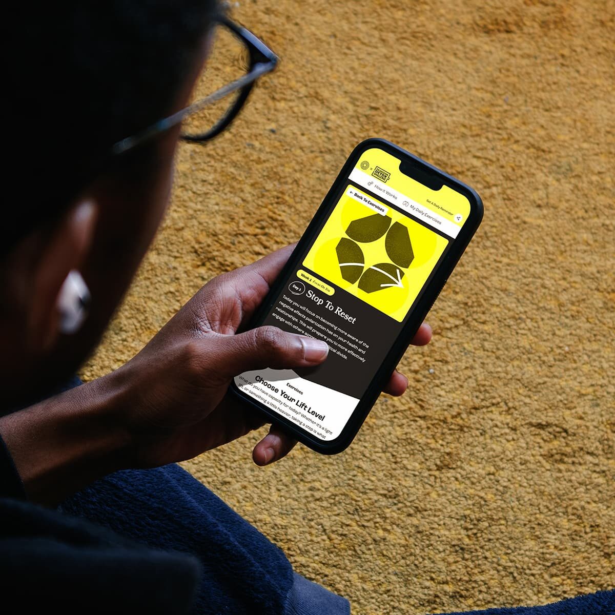 A Black man navigating the Polarization Detox Website on his smartphone, exploring the different exercises.